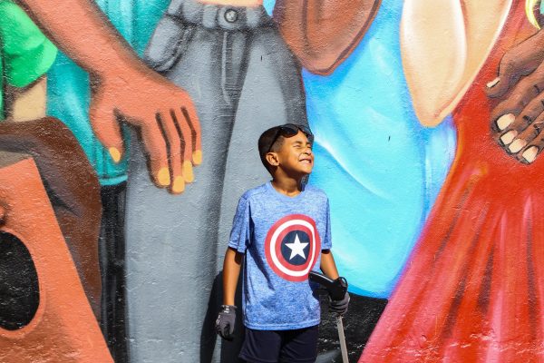 Debris Free Oceans cleanup participant in front of a mural